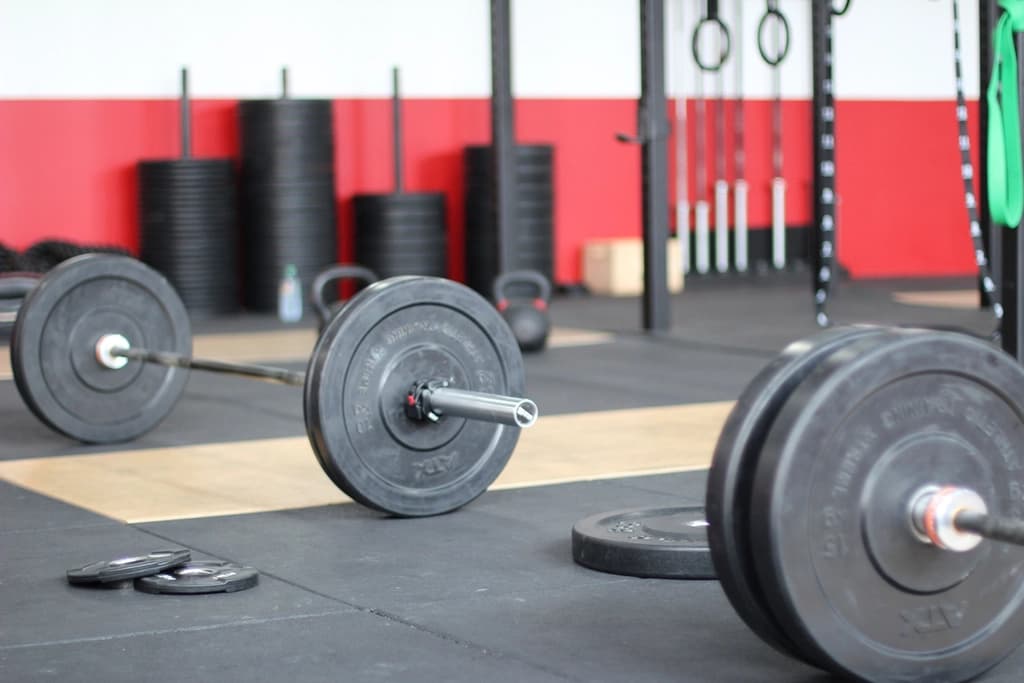 Barbells and weight plates on the floor of a strength training room